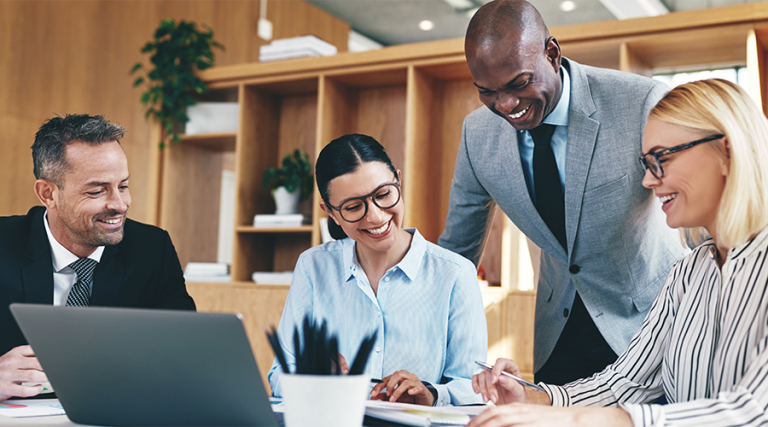 Diverse group of businesspeople laughing together during an office meeting