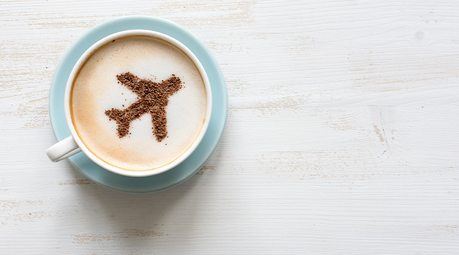 Airplane made of cinnamon in coffee. Cup of Cappuccino. Travel concept