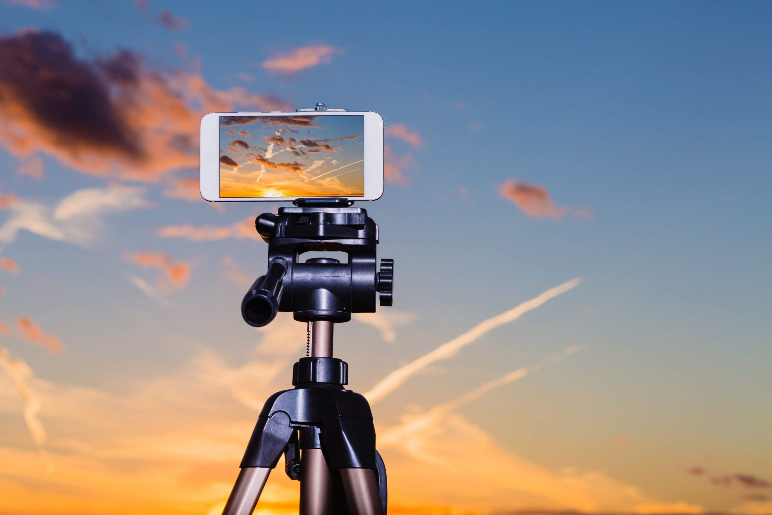 Smartphone on tripod capturing image of stunning sundown