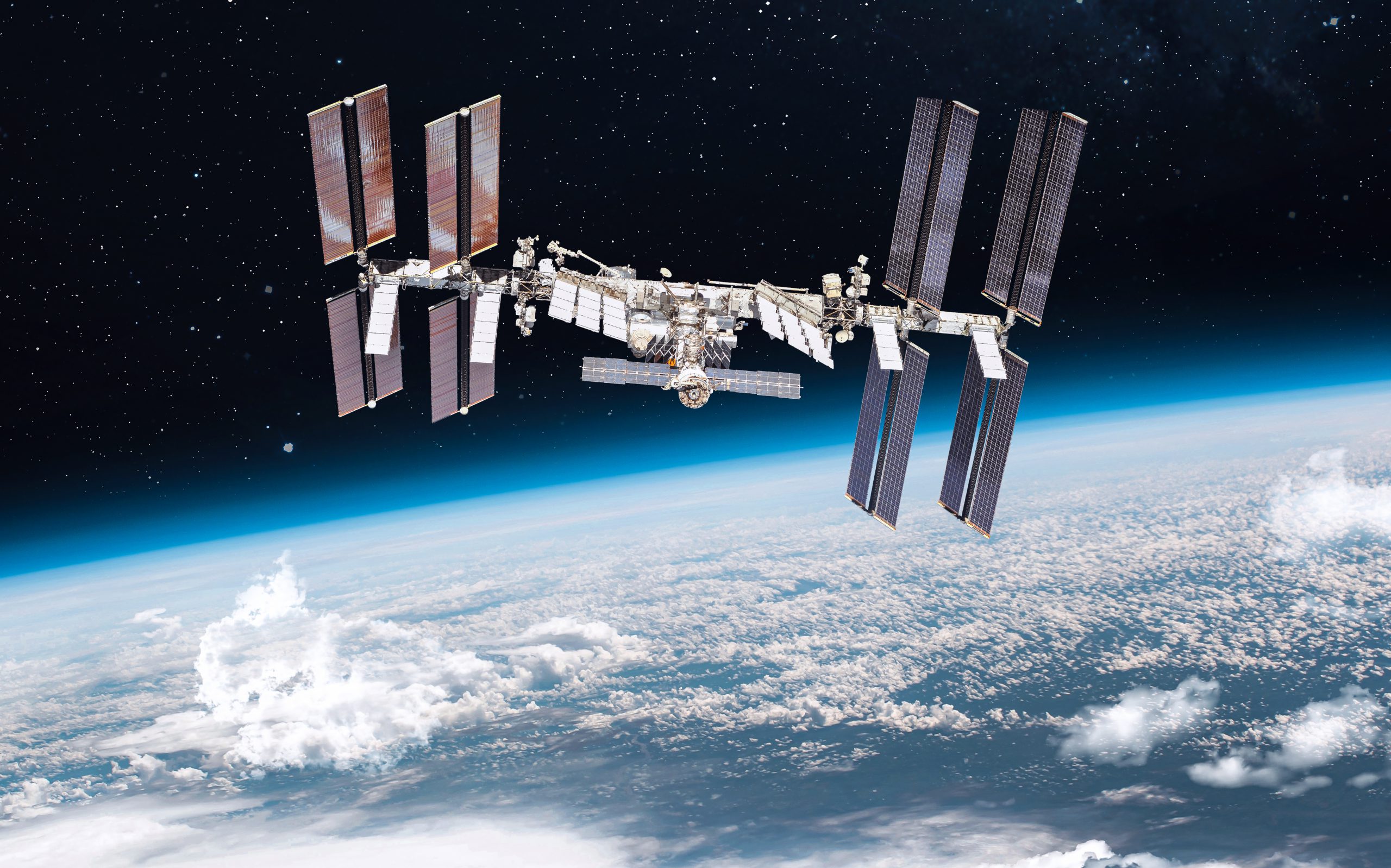 Image of the International Space Station with Earth in the background. The ISS can host research for advanced materials.