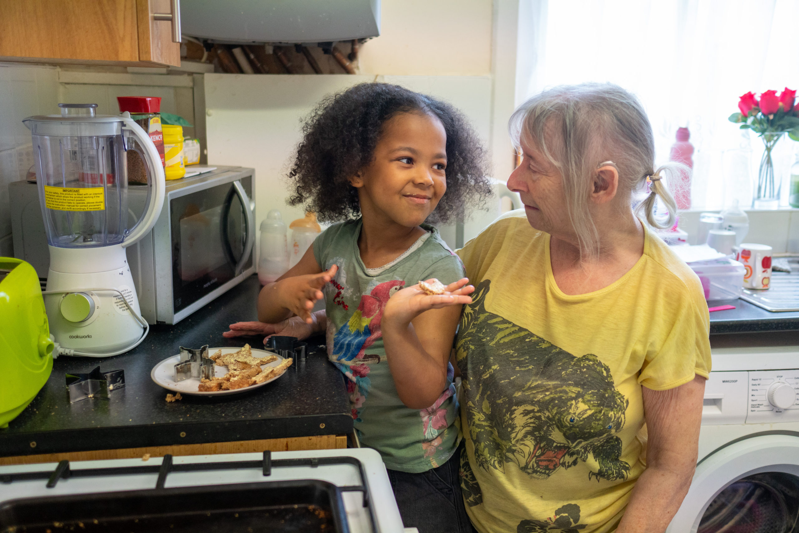 child and grandparent in kitchen together