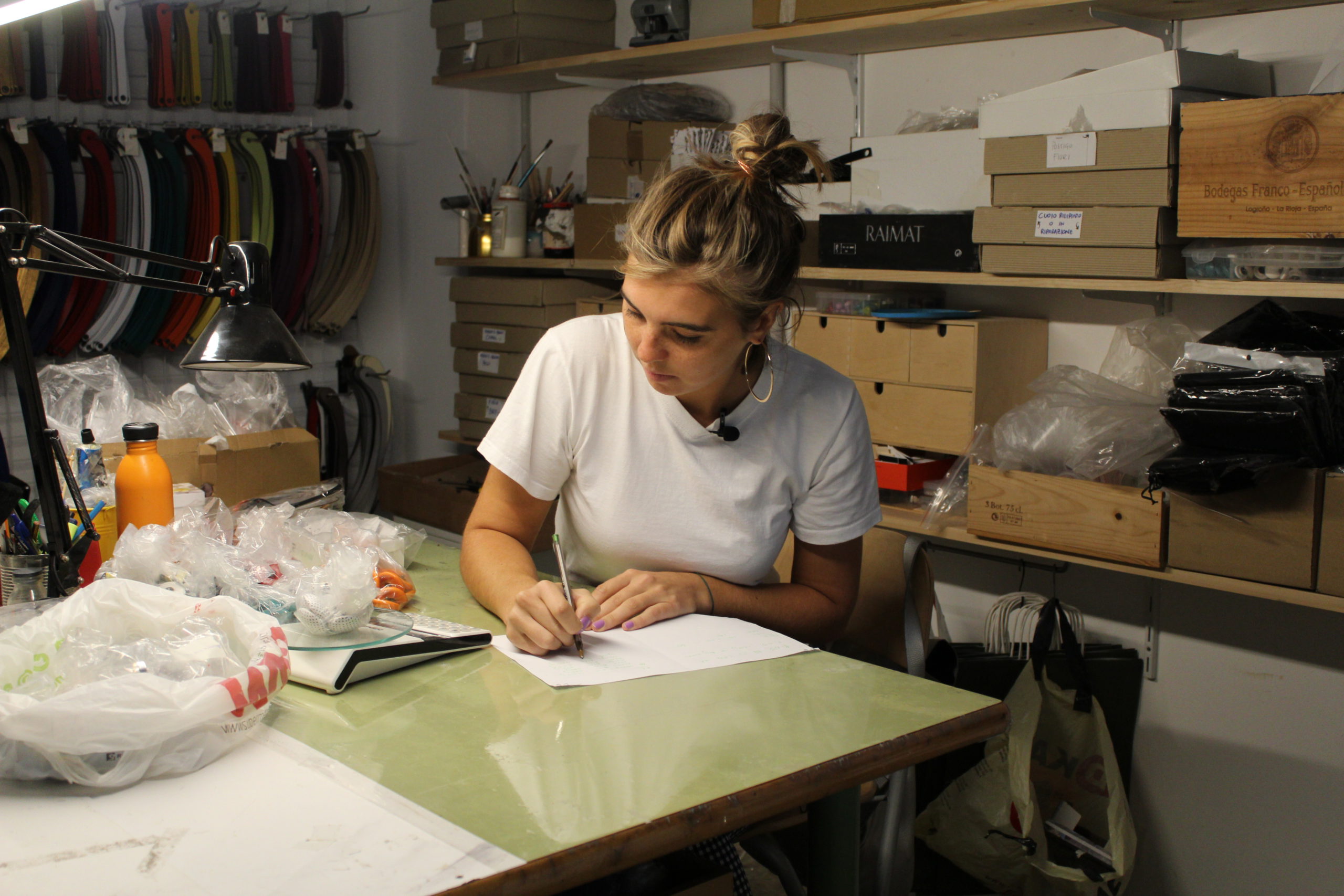 Ella Merriman, working at a table, designing on a sheet of paper