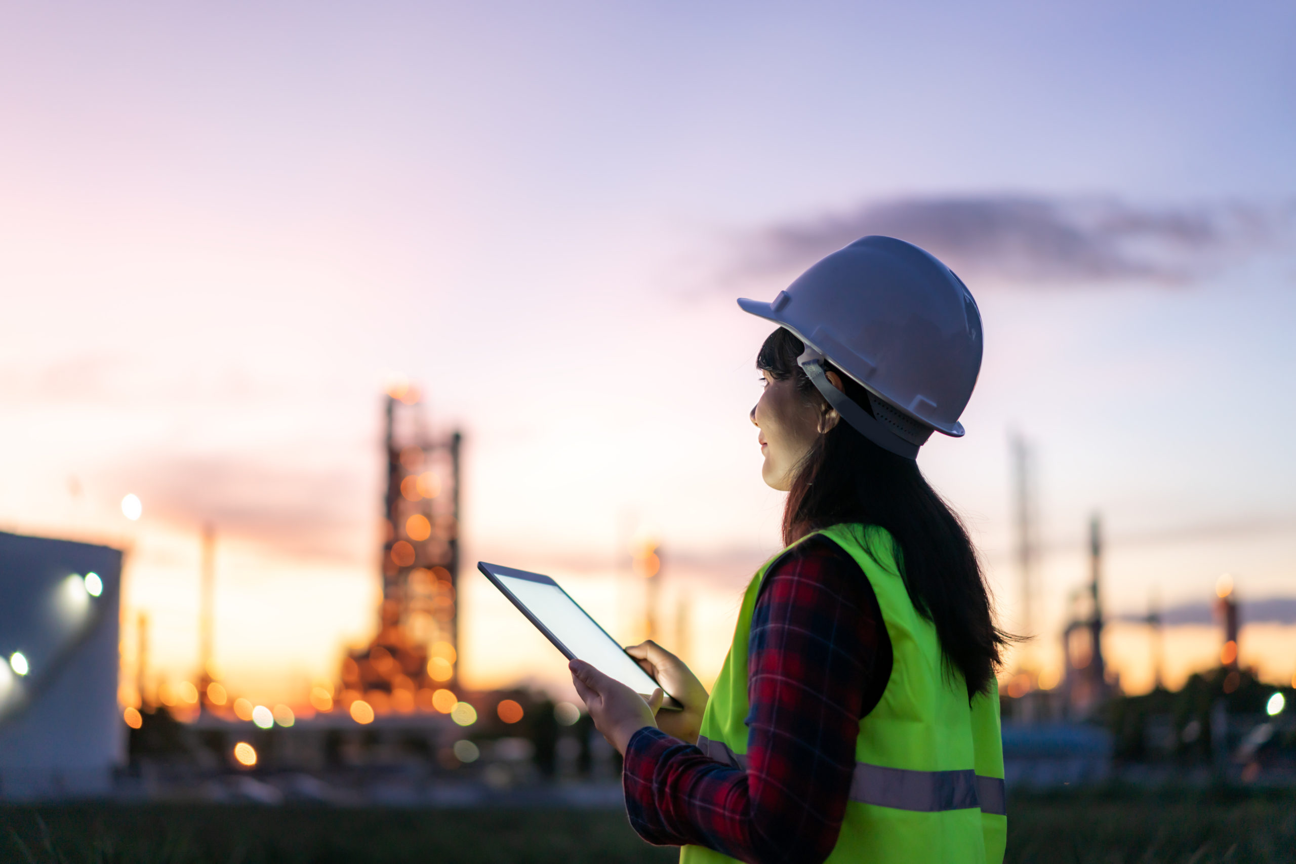 Asian woman petrochemical engineer working at night with digital