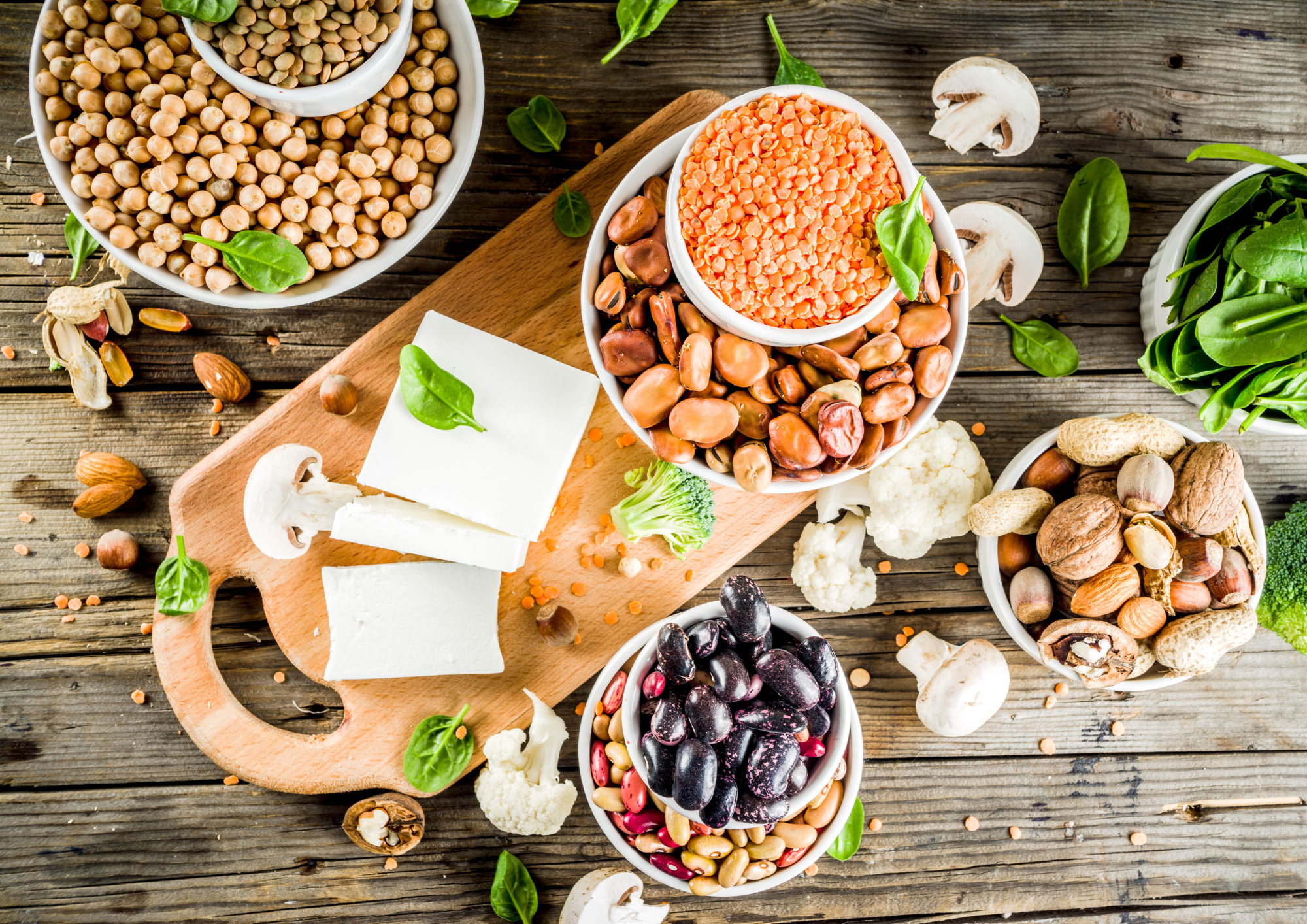 Different types of plant based protein sources laid out on a wooden background