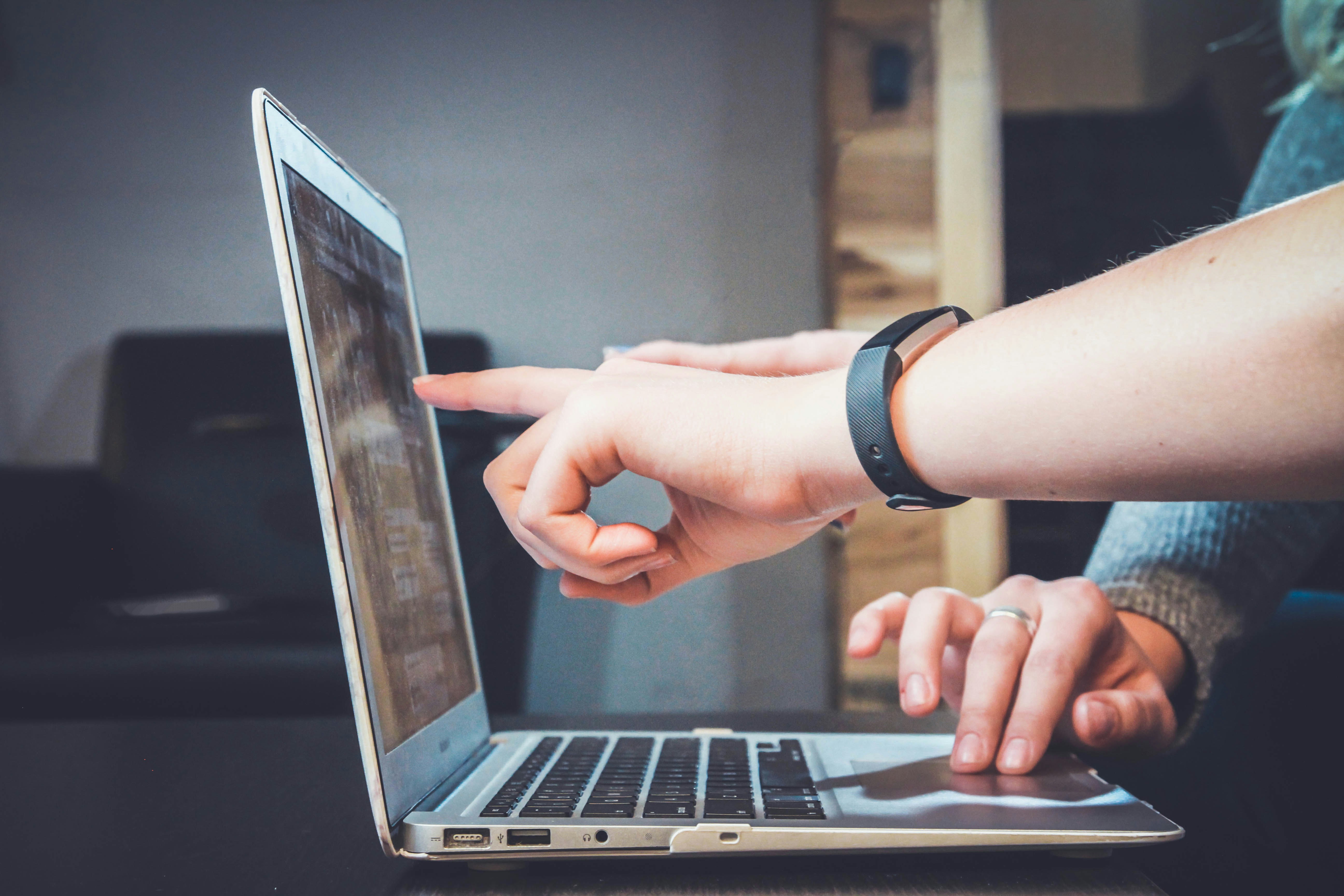 someone pointing at a laptop screen